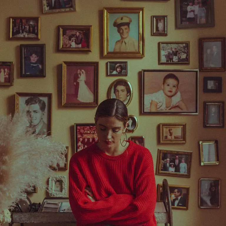 Samantha Scaffidi in front of portraits of her family members posing for a picture.