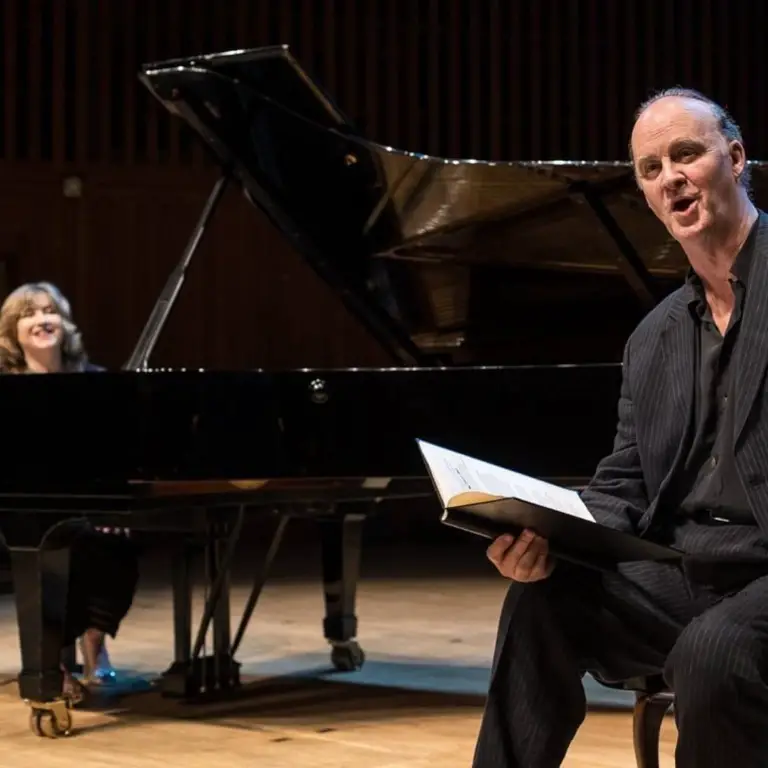 Tim McInnerny performing on stage with pianist