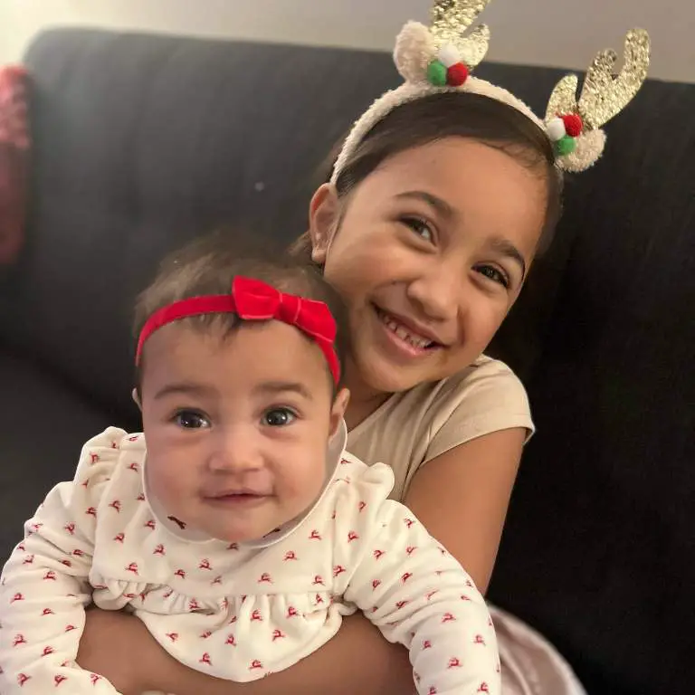 Uli Latukefu's elder daughter and younger daughter taking a sibling picture on holiday.