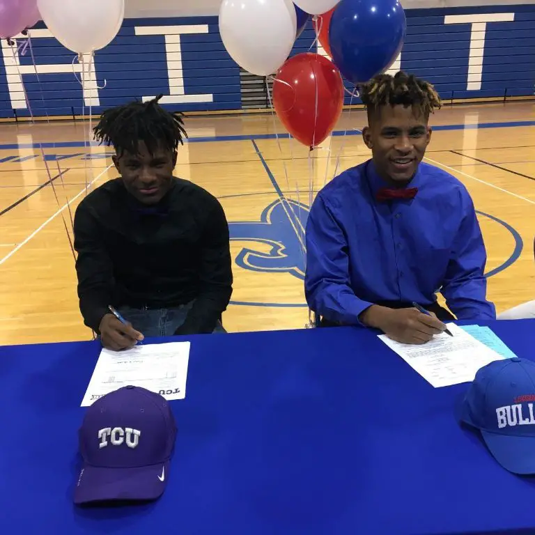 Brothers Derius Davis, left, and Derek Turner, right, sign letters of intent to respective schools on National Signing Day.