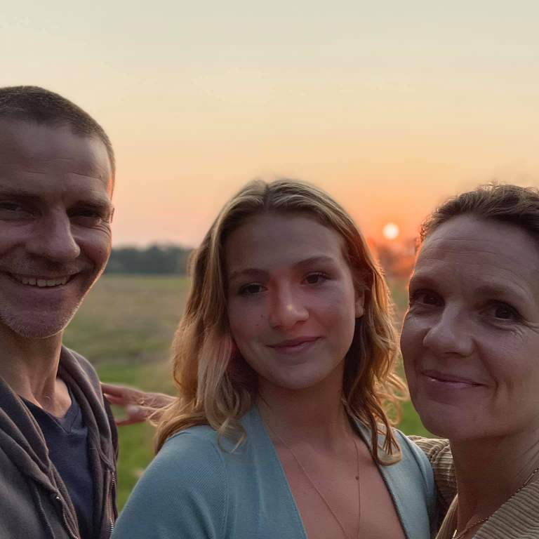 Isabela Ferrer with her parents enjoying the view with sunset during their trip