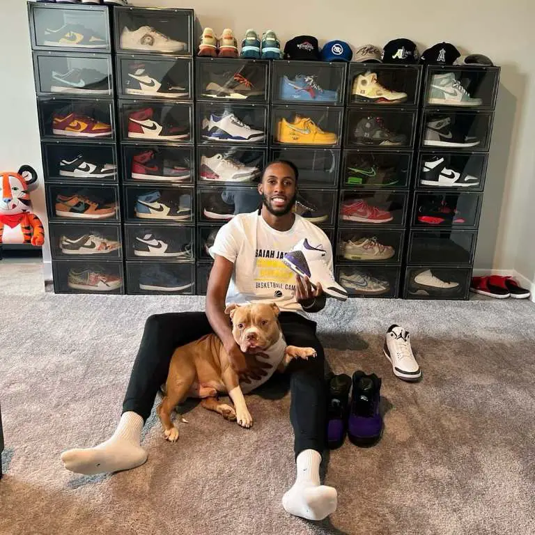 Isaiah Jackson poses with huge pile of his branded sneakers.