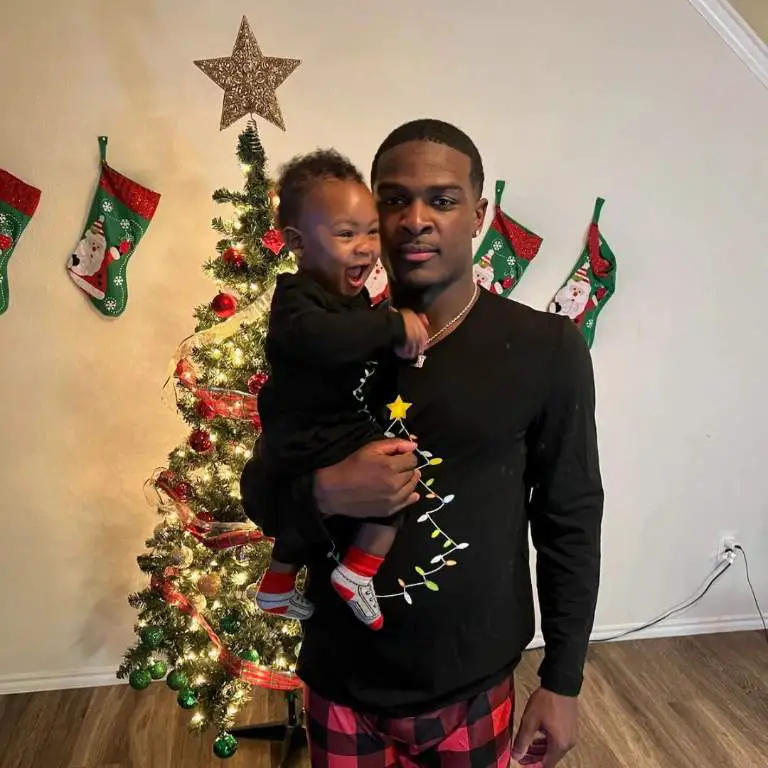 De'Von Achane posing for a picture with his son celebrating Christmas