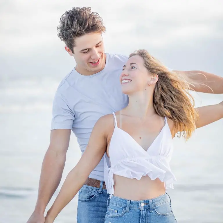 Luke McCaffrey posing with his girlfriend at a beach