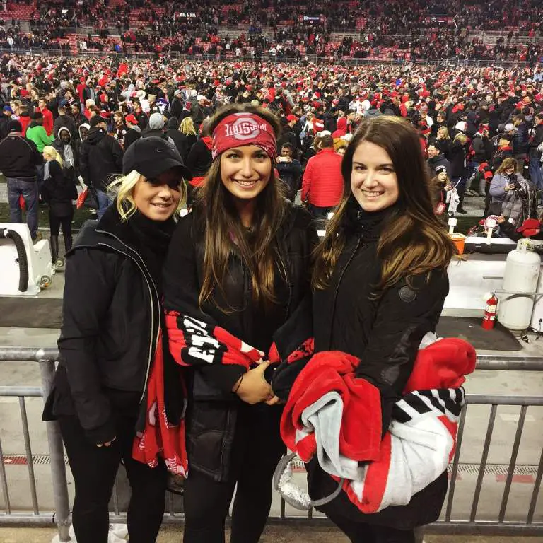 Olivia with her sisters posing for a picture before her boyfriend's game