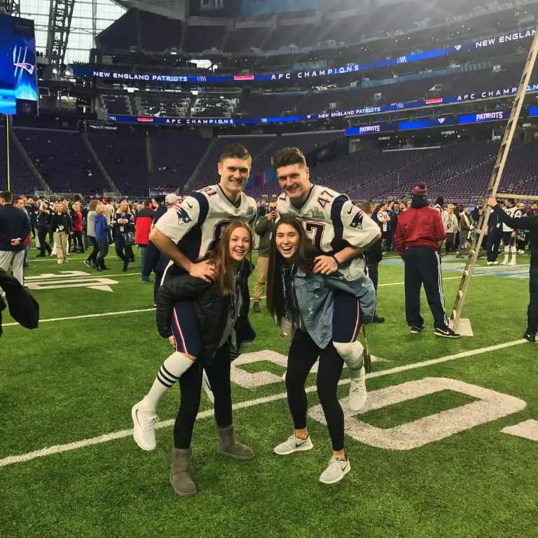 Sierra Sudfeld with her sister posing for a picture with their twin brothers during their game